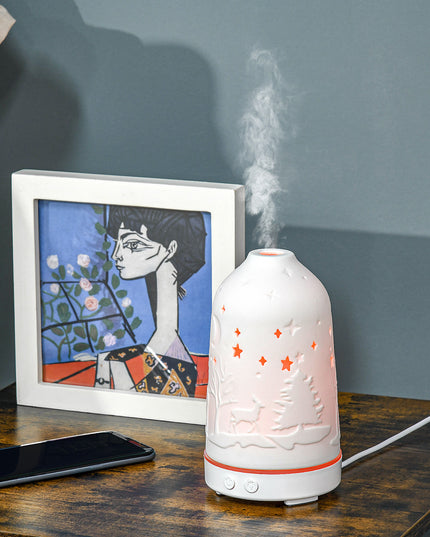 100ml Ultrasonic Aromatherapy Diffuser auf einem Tisch mit Nebel und Kunstwerk im Hintergrund.